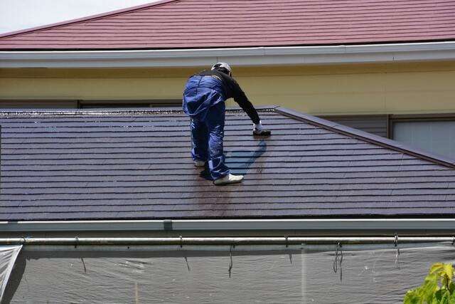 屋根塗装をする男性